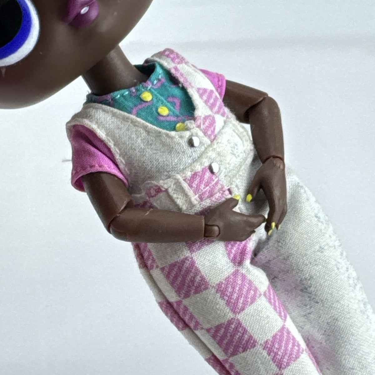 MGA LOL Surprise Tweens Winnie fashion doll in split checkered overalls with two-tone curly afro puff buns.