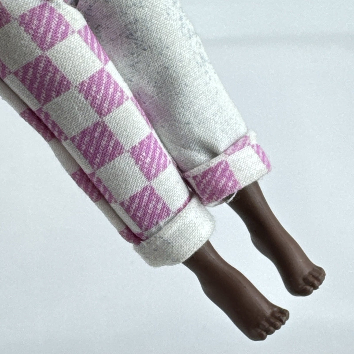 MGA LOL Surprise Tweens Winnie fashion doll in split checkered overalls with two-tone curly afro puff buns.