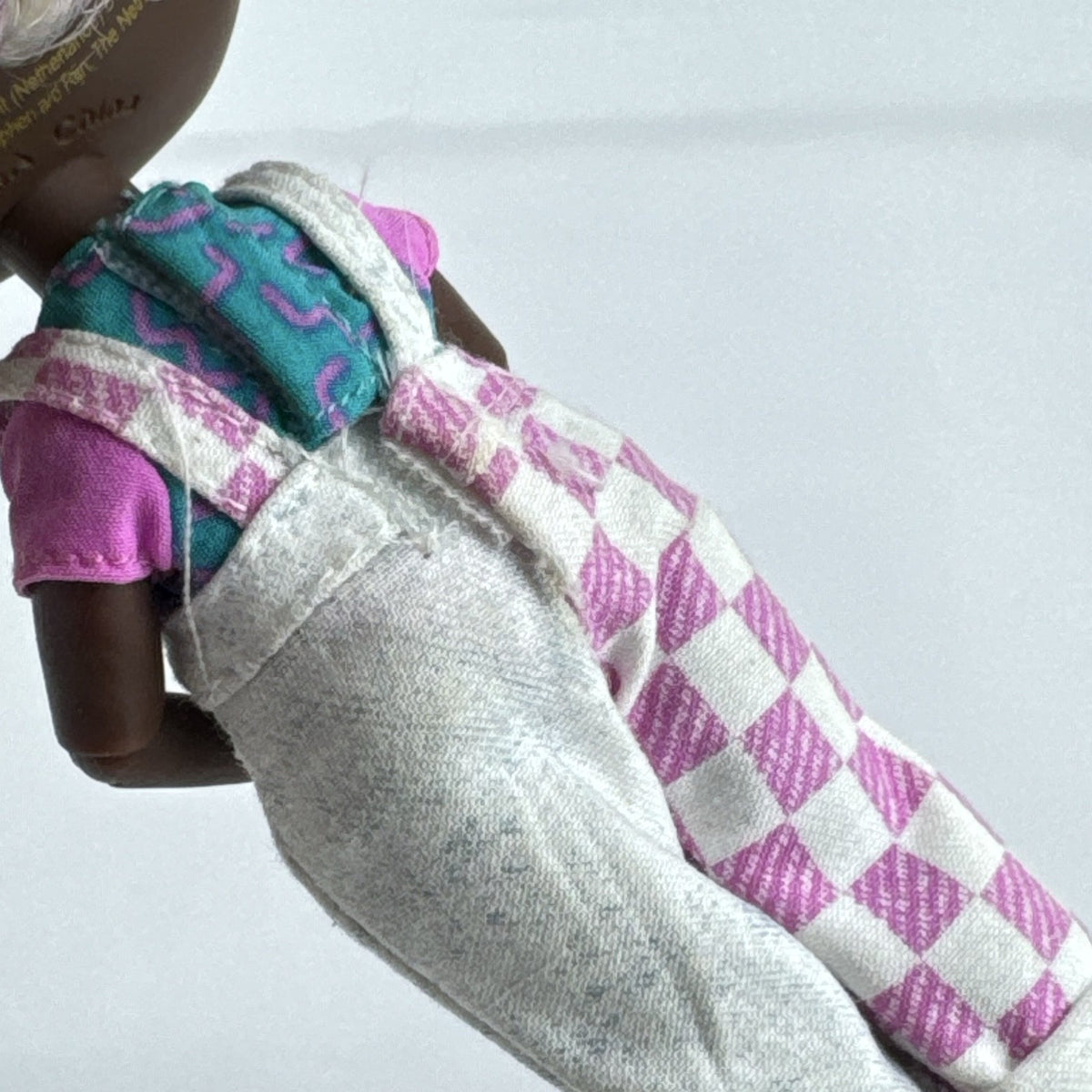 MGA LOL Surprise Tweens Winnie fashion doll in split checkered overalls with two-tone curly afro puff buns.
