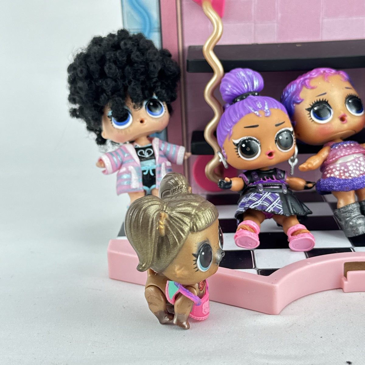 MGA L.O.L. Surprise stage playset featuring a pink arched backdrop, checkered floor, five mini dolls, and two pets
