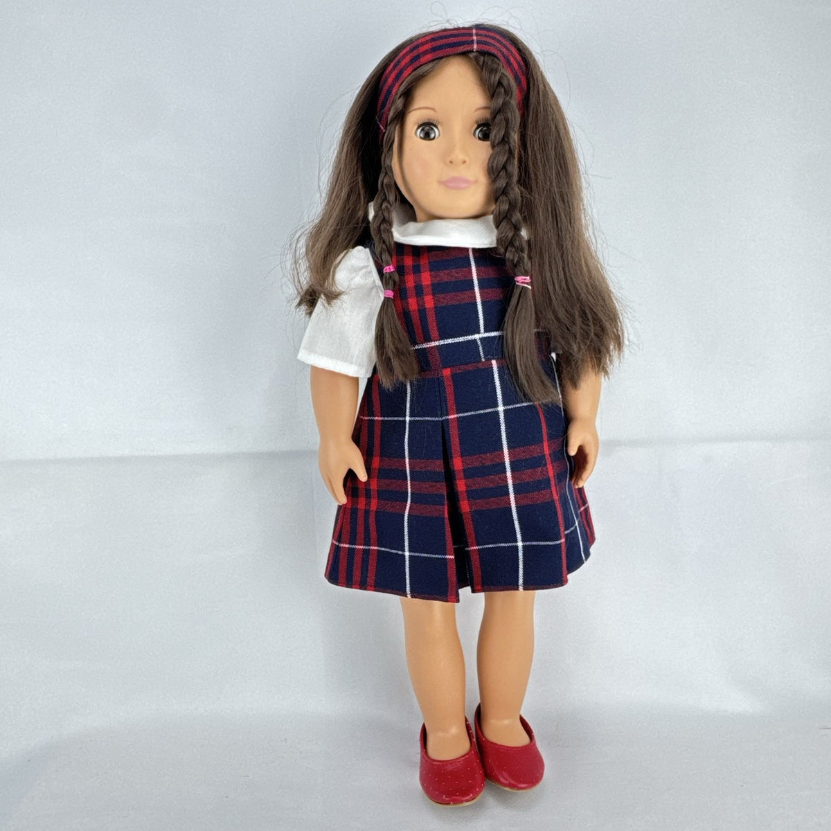 Battat Our Generation 18-inch doll with brown hair and eyes in red and navy plaid school uniform dress and red shoes