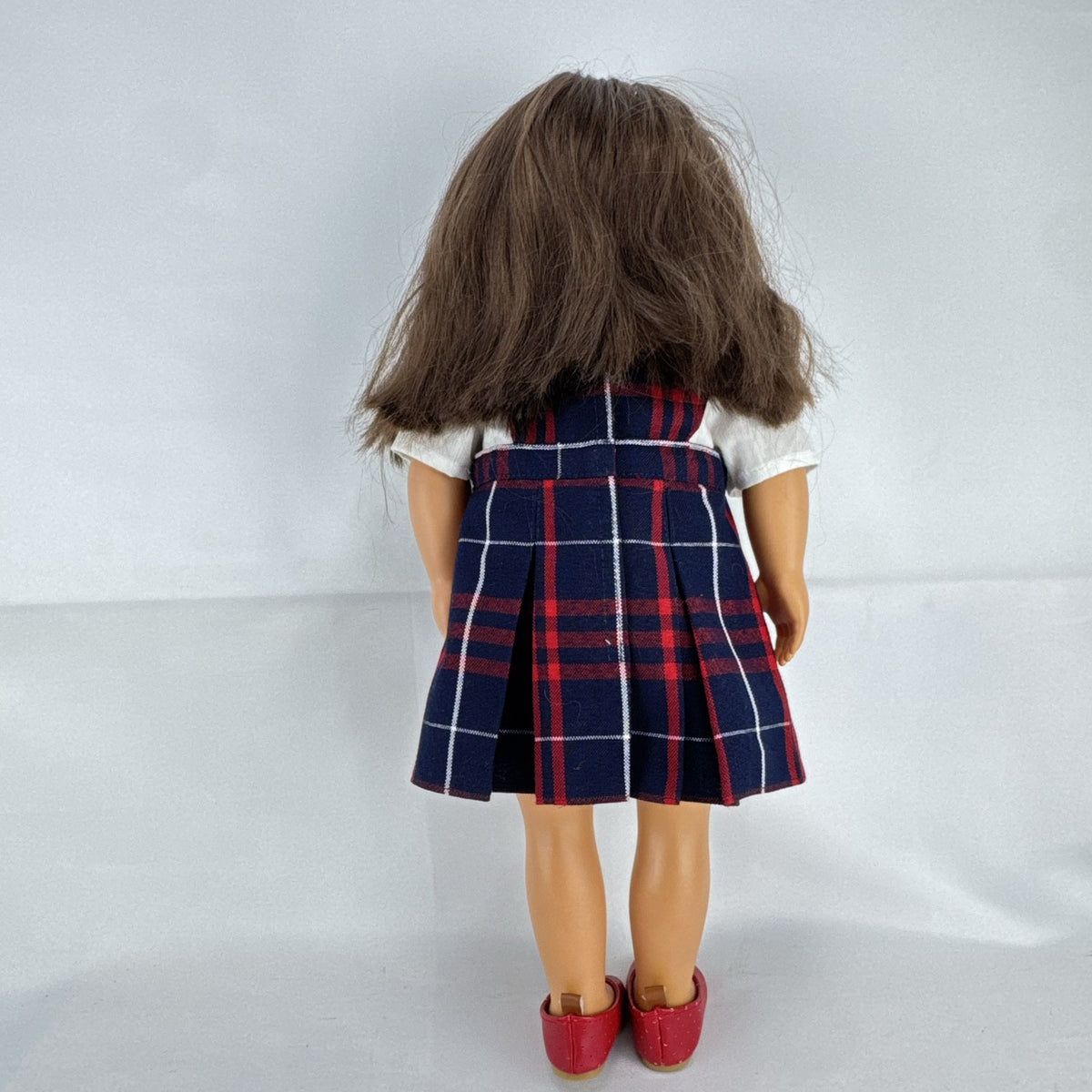 Battat Our Generation 18-inch doll with brown hair and eyes in red and navy plaid school uniform dress and red shoes