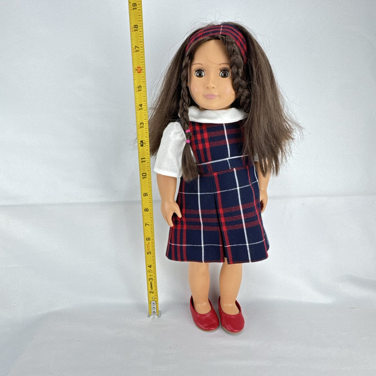 Battat Our Generation 18-inch doll with brown hair and eyes in red and navy plaid school uniform dress and red shoes
