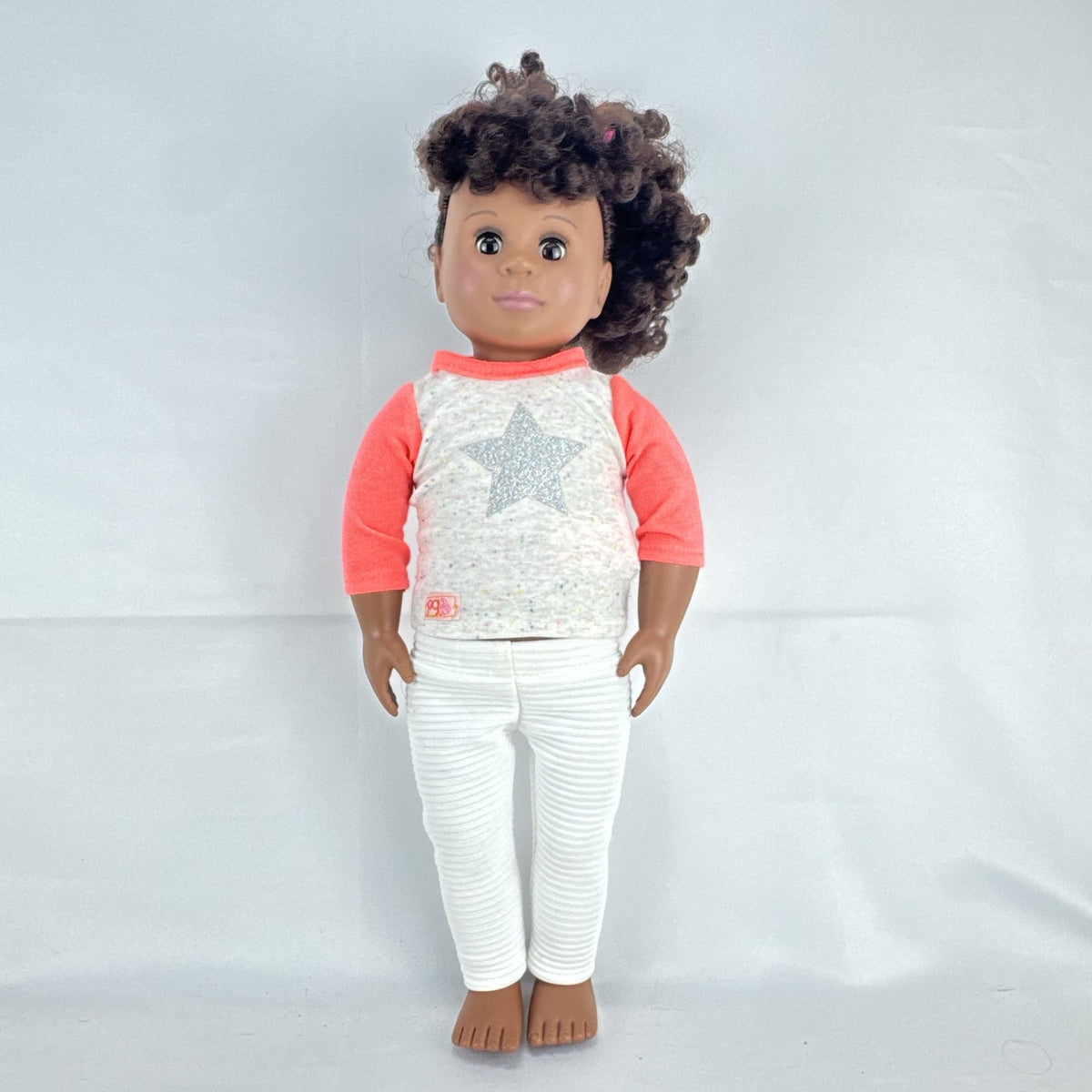 Battat Our Generation 18-inch African American doll with curly dark brown hair wearing a star shirt and white pants