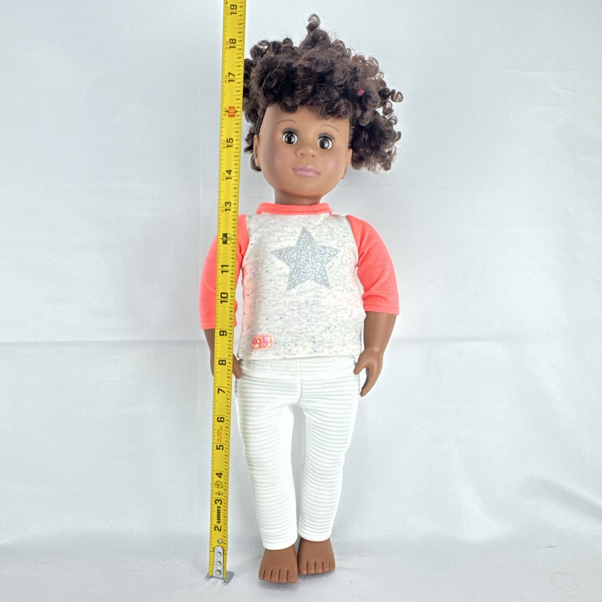Battat Our Generation 18-inch African American doll with curly dark brown hair wearing a star shirt and white pants