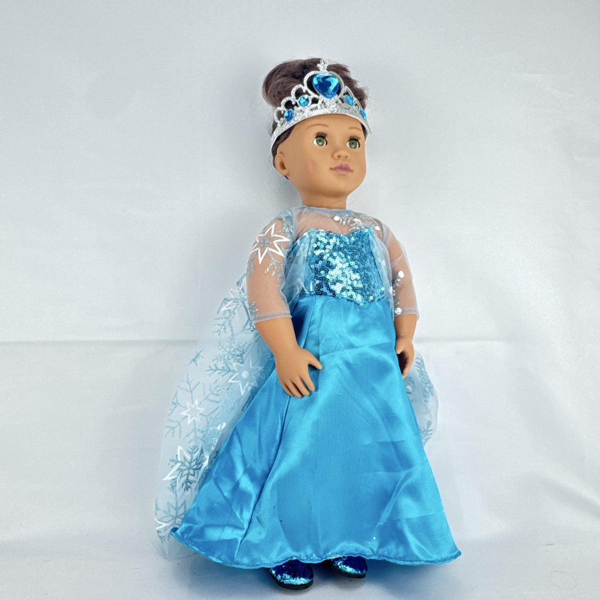 Our Generation 18-inch brunette doll with green eyes wearing a blue sequin ice princess gown and tiara
