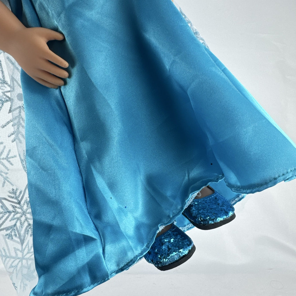 Our Generation 18-inch brunette doll with green eyes wearing a blue sequin ice princess gown and tiara