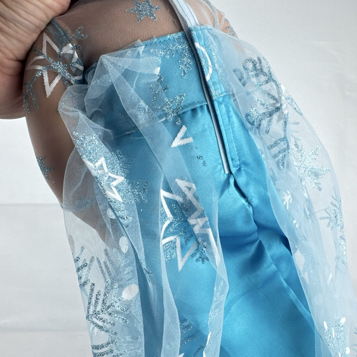 Our Generation 18-inch brunette doll with green eyes wearing a blue sequin ice princess gown and tiara