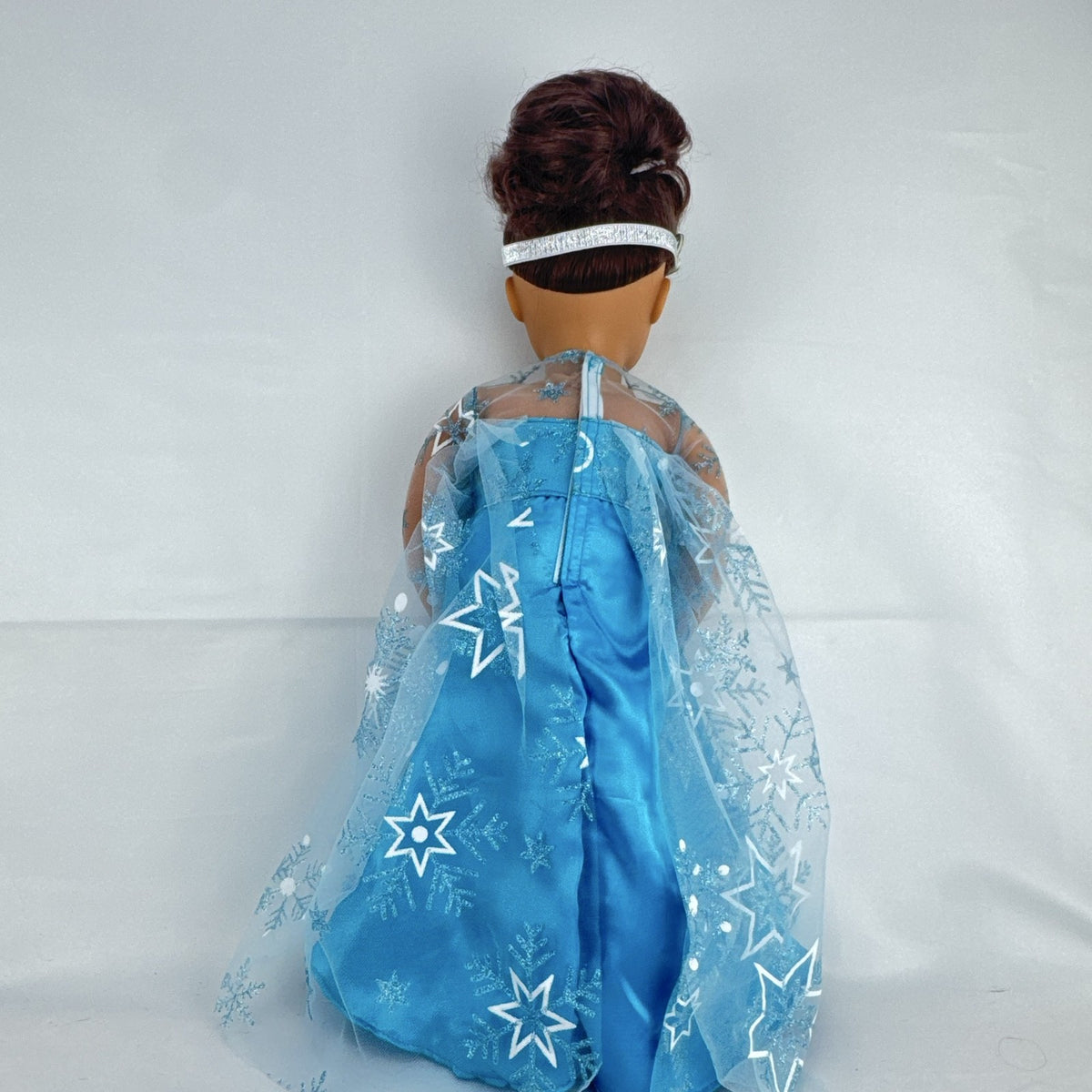 Our Generation 18-inch brunette doll with green eyes wearing a blue sequin ice princess gown and tiara