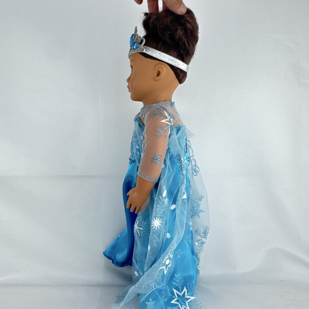 Our Generation 18-inch brunette doll with green eyes wearing a blue sequin ice princess gown and tiara