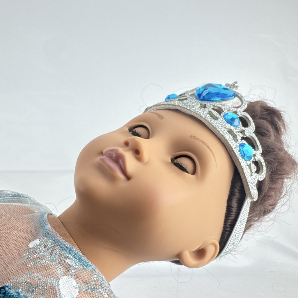 Our Generation 18-inch brunette doll with green eyes wearing a blue sequin ice princess gown and tiara