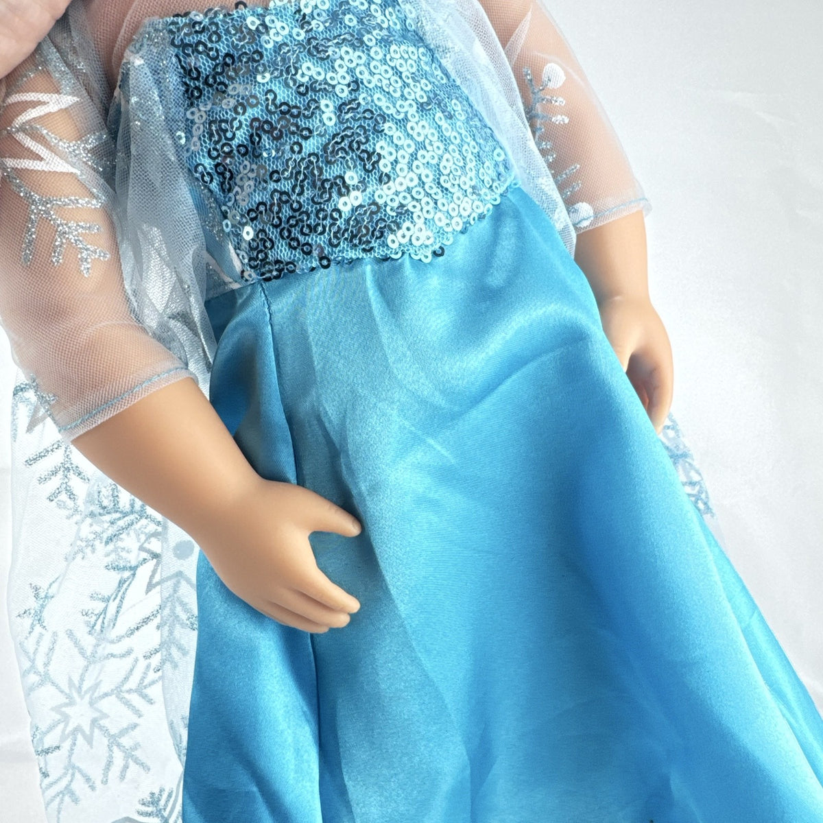 Our Generation 18-inch brunette doll with green eyes wearing a blue sequin ice princess gown and tiara