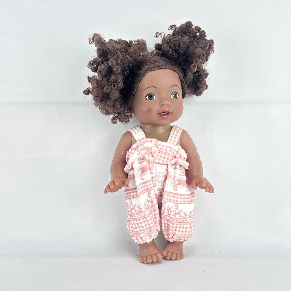 Smart Zone 10-inch African American vinyl baby doll with dark brown curly afro puff pigtails in a pink reindeer romper