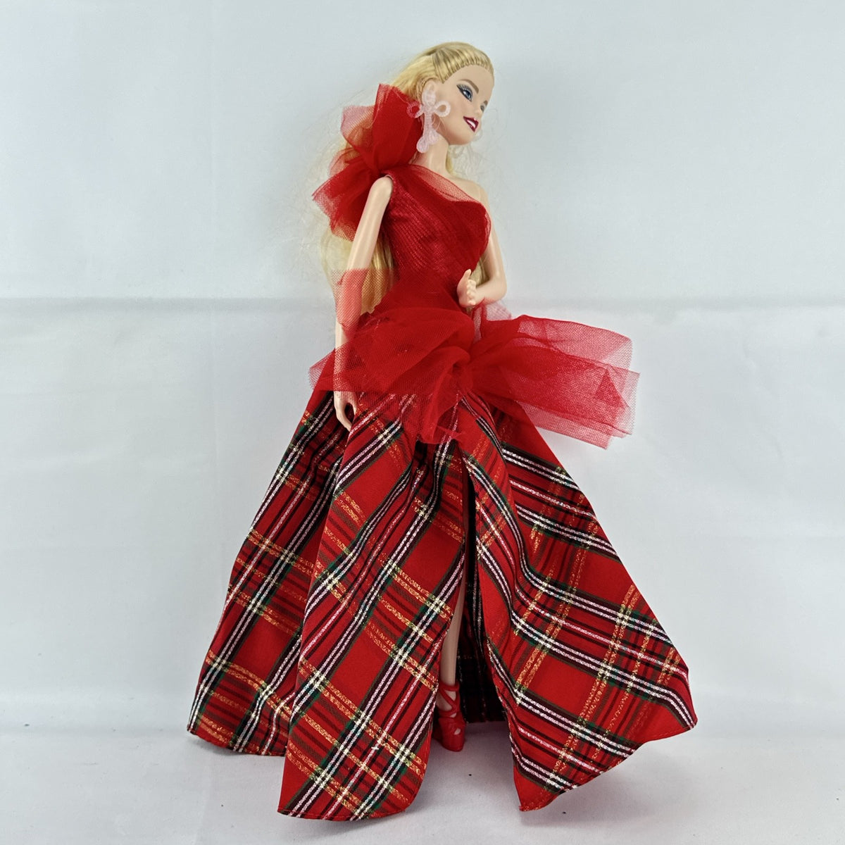 2024 Mattel Holiday Barbie doll wearing an asymmetrical red tartan plaid ball gown with tulle accent