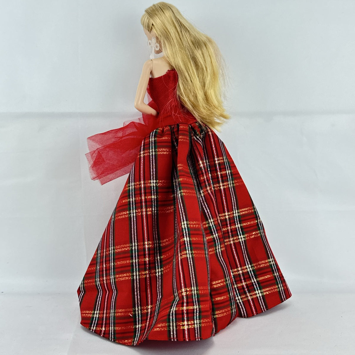 2024 Mattel Holiday Barbie doll wearing an asymmetrical red tartan plaid ball gown with tulle accent