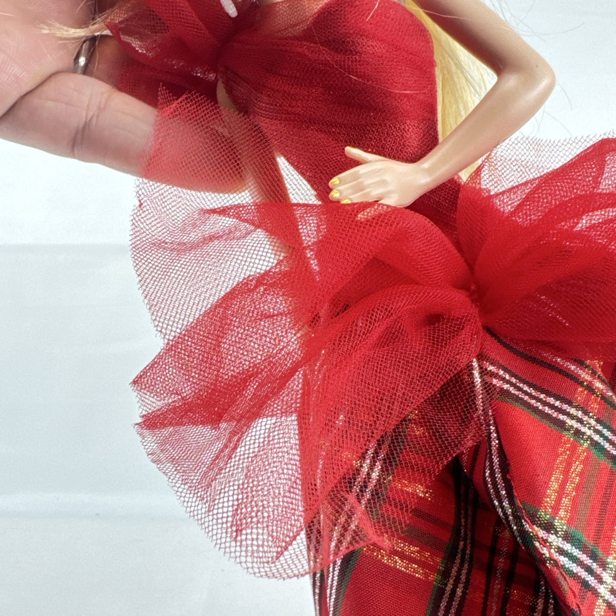 2024 Mattel Holiday Barbie doll wearing an asymmetrical red tartan plaid ball gown with tulle accent