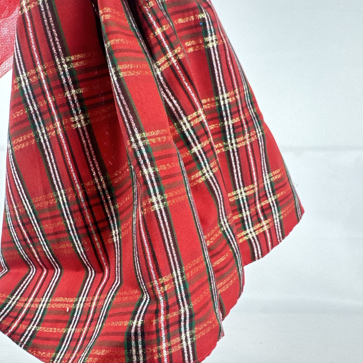 2024 Mattel Holiday Barbie doll wearing an asymmetrical red tartan plaid ball gown with tulle accent