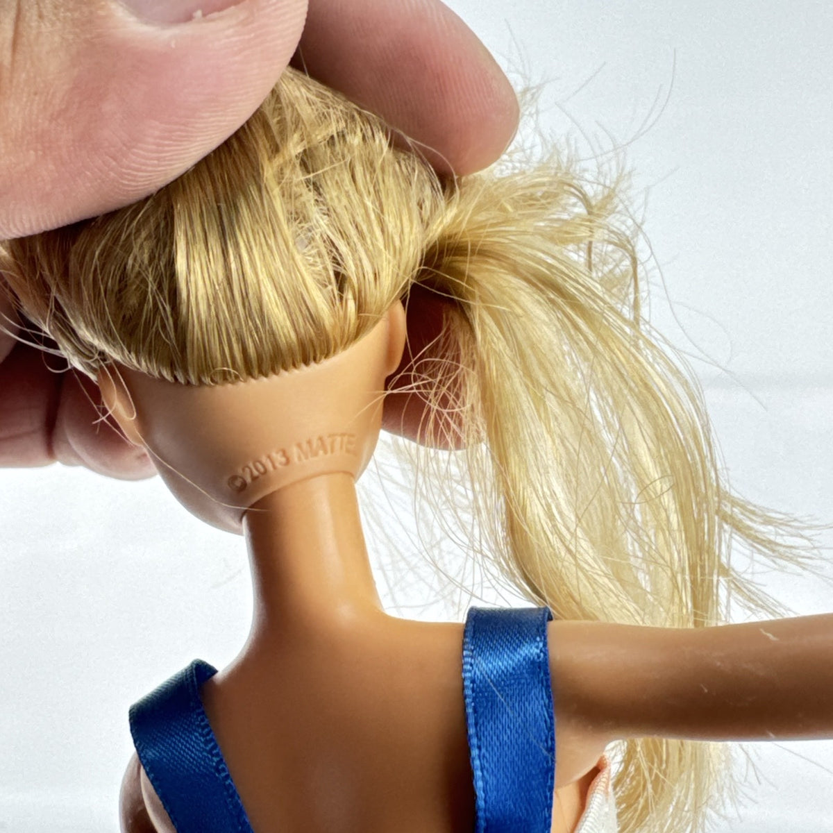 Mattel Barbie fashion doll with blonde hair wearing an orange fringe skirt and floral top