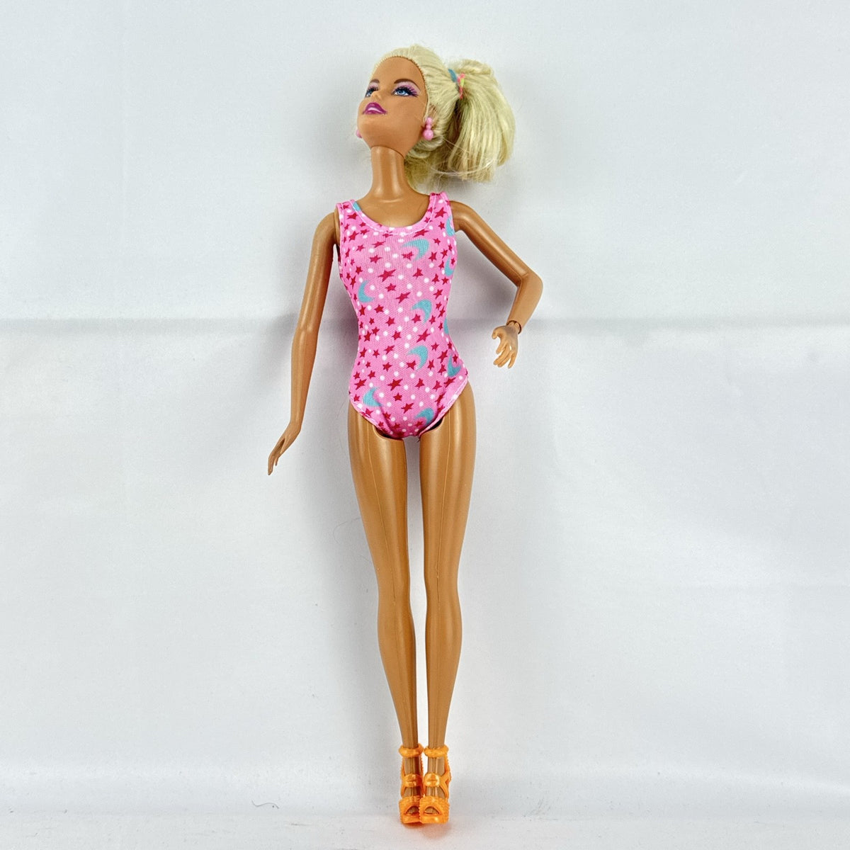 1998 Mattel Barbie doll with blonde side ponytail, celestial star swimsuit, and orange heels