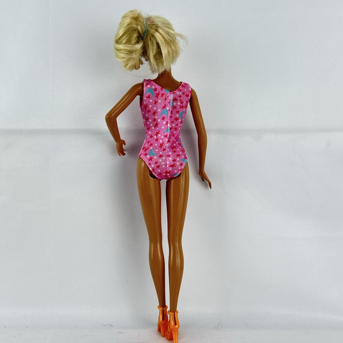 1998 Mattel Barbie doll with blonde side ponytail, celestial star swimsuit, and orange heels
