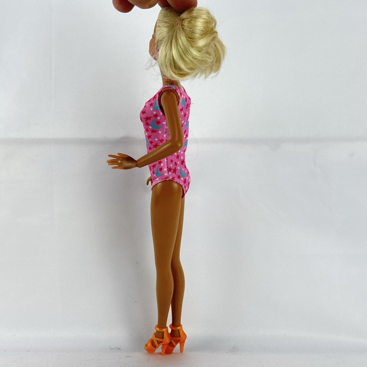1998 Mattel Barbie doll with blonde side ponytail, celestial star swimsuit, and orange heels