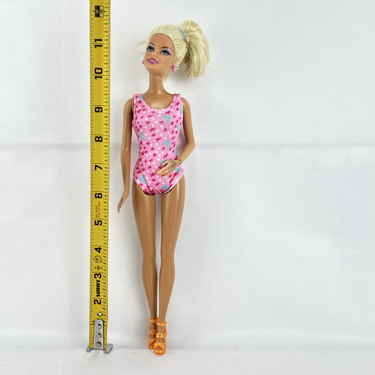 1998 Mattel Barbie doll with blonde side ponytail, celestial star swimsuit, and orange heels