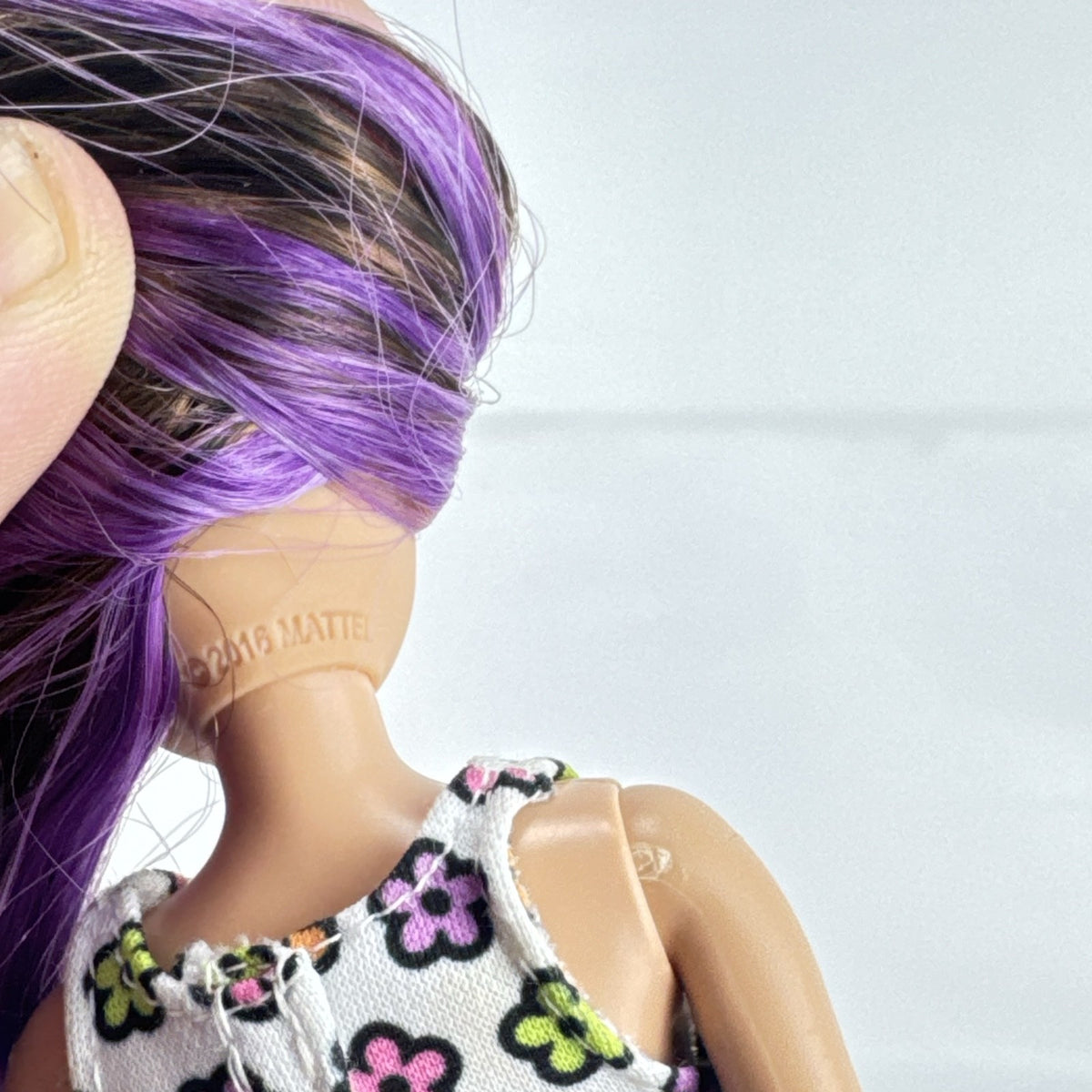 Mattel Barbie Skipper 10-inch doll with purple streaked brown hair in a floral mini dress and pink shoes