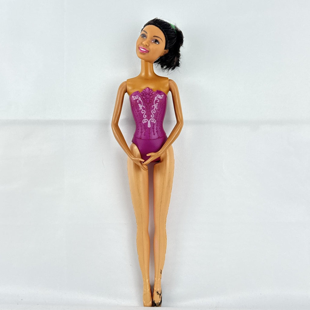 Mattel African American Barbie ballerina doll in molded purple bodice posed on pointe.