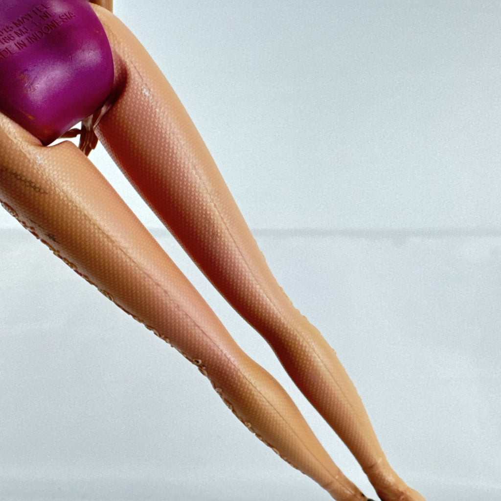 Mattel African American Barbie ballerina doll in molded purple bodice posed on pointe.