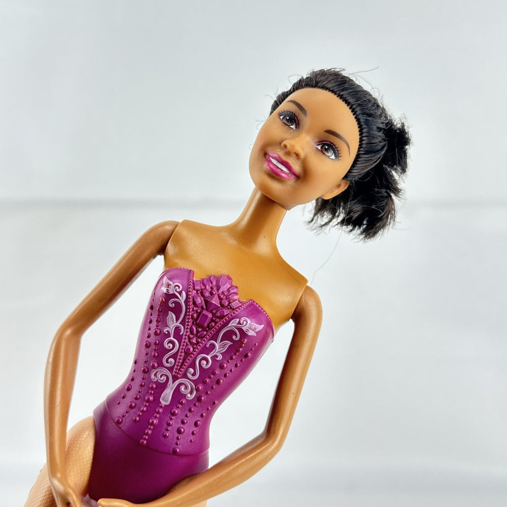 Mattel African American Barbie ballerina doll in molded purple bodice posed on pointe.