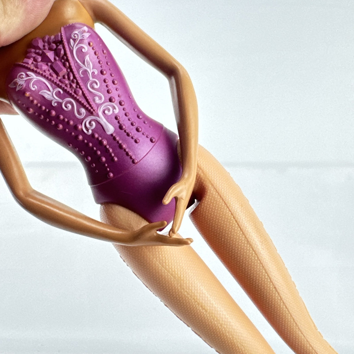 Mattel African American Barbie ballerina doll in molded purple bodice posed on pointe.
