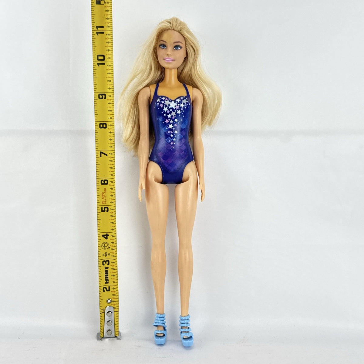 Blonde Mattel Barbie doll wearing a molded blue star swimsuit and matching blue strappy heels