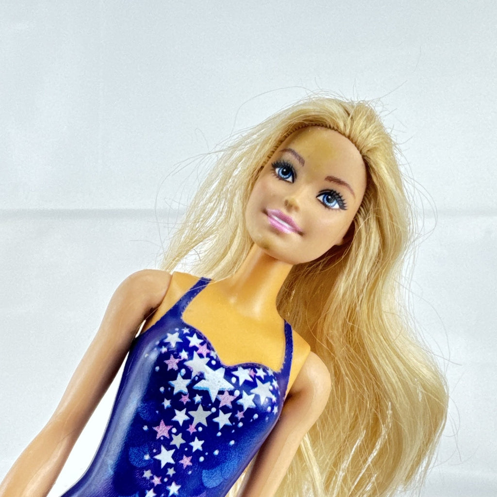 Blonde Mattel Barbie doll wearing a molded blue star swimsuit and matching blue strappy heels