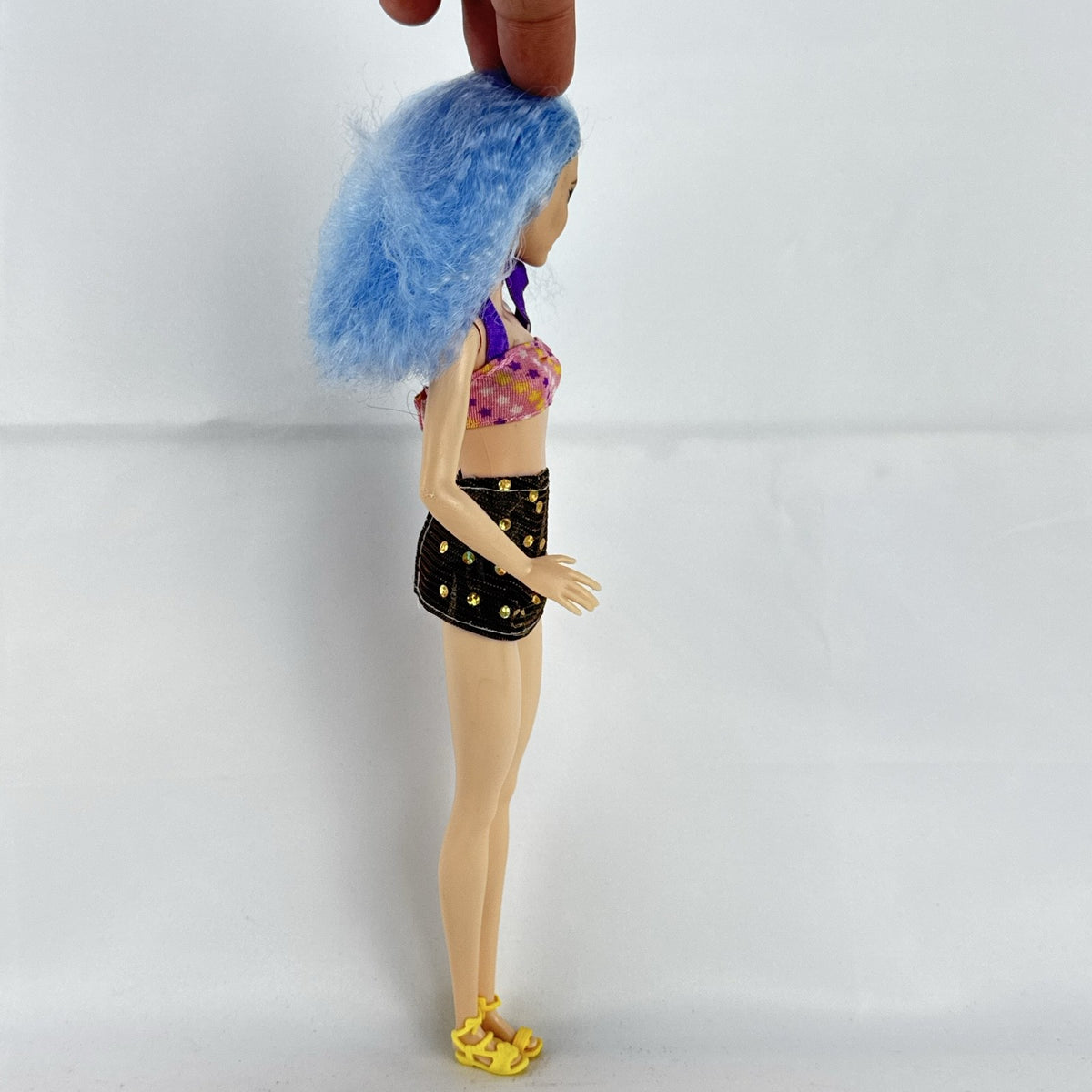 Mattel Barbie Fashionistas 12-inch doll with curly light blue hair, halter crop top, and gold sequin skirt