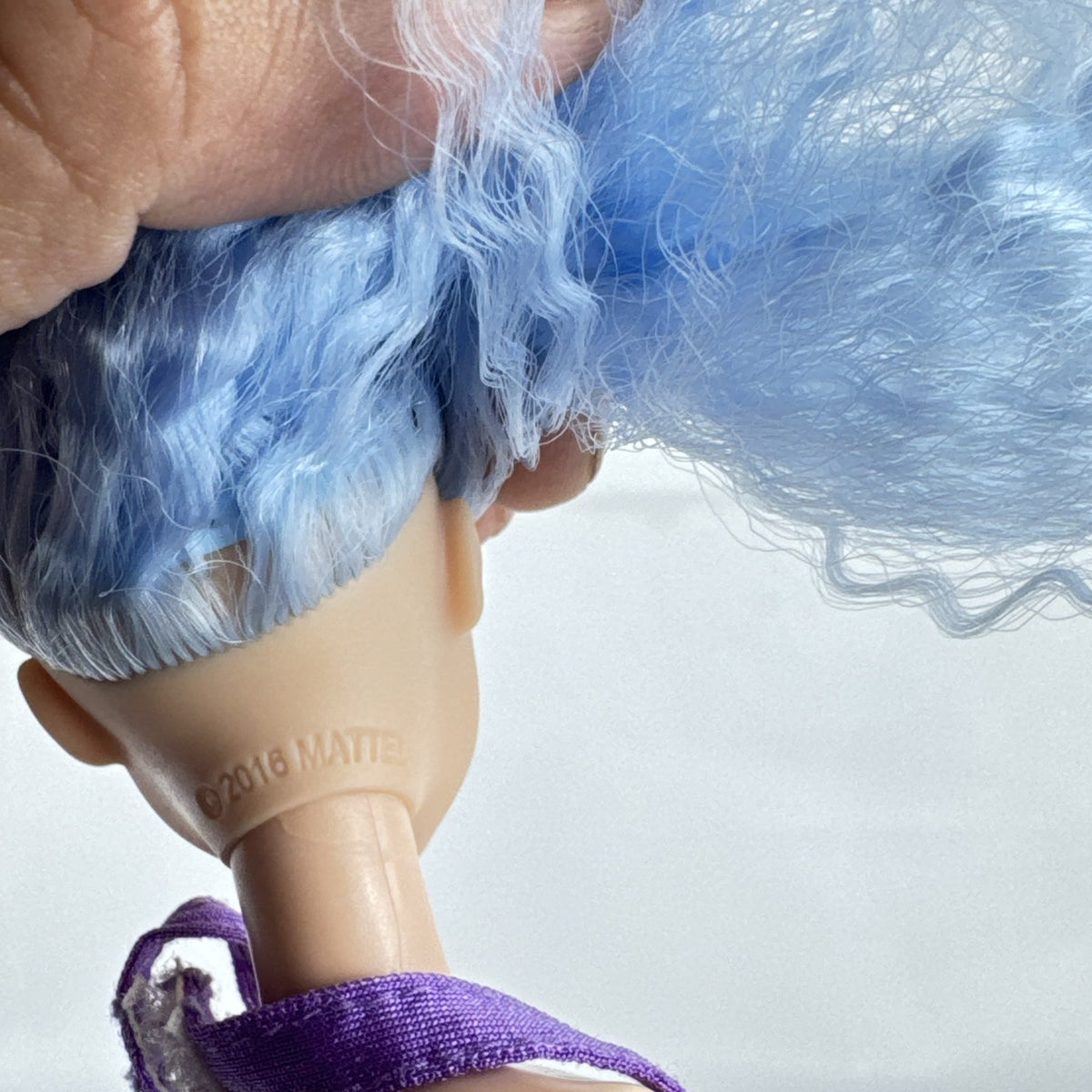Mattel Barbie Fashionistas 12-inch doll with curly light blue hair, halter crop top, and gold sequin skirt