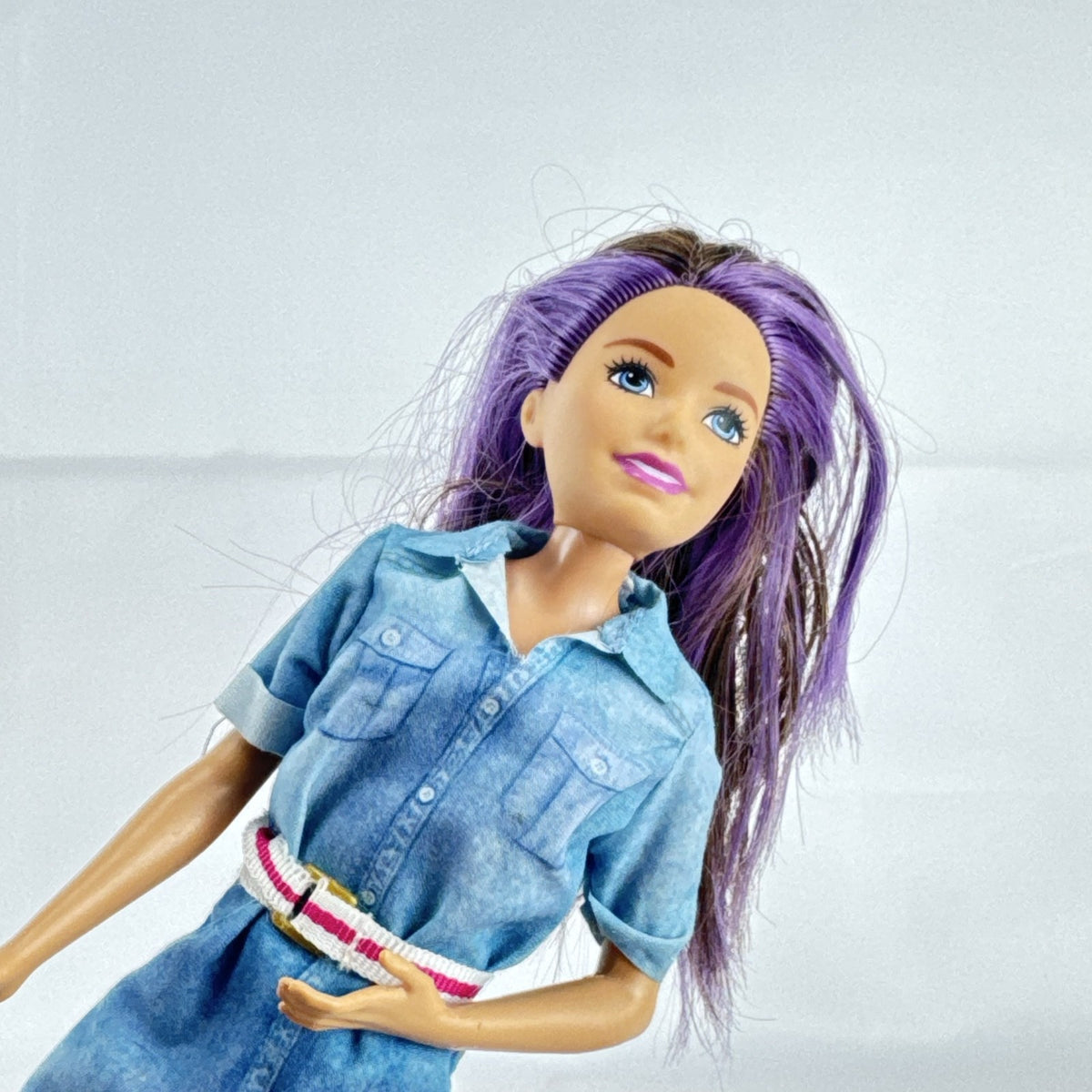 Mattel Barbie Dreamhouse Adventures Skipper doll with purple hair in denim tunic and white shoes
