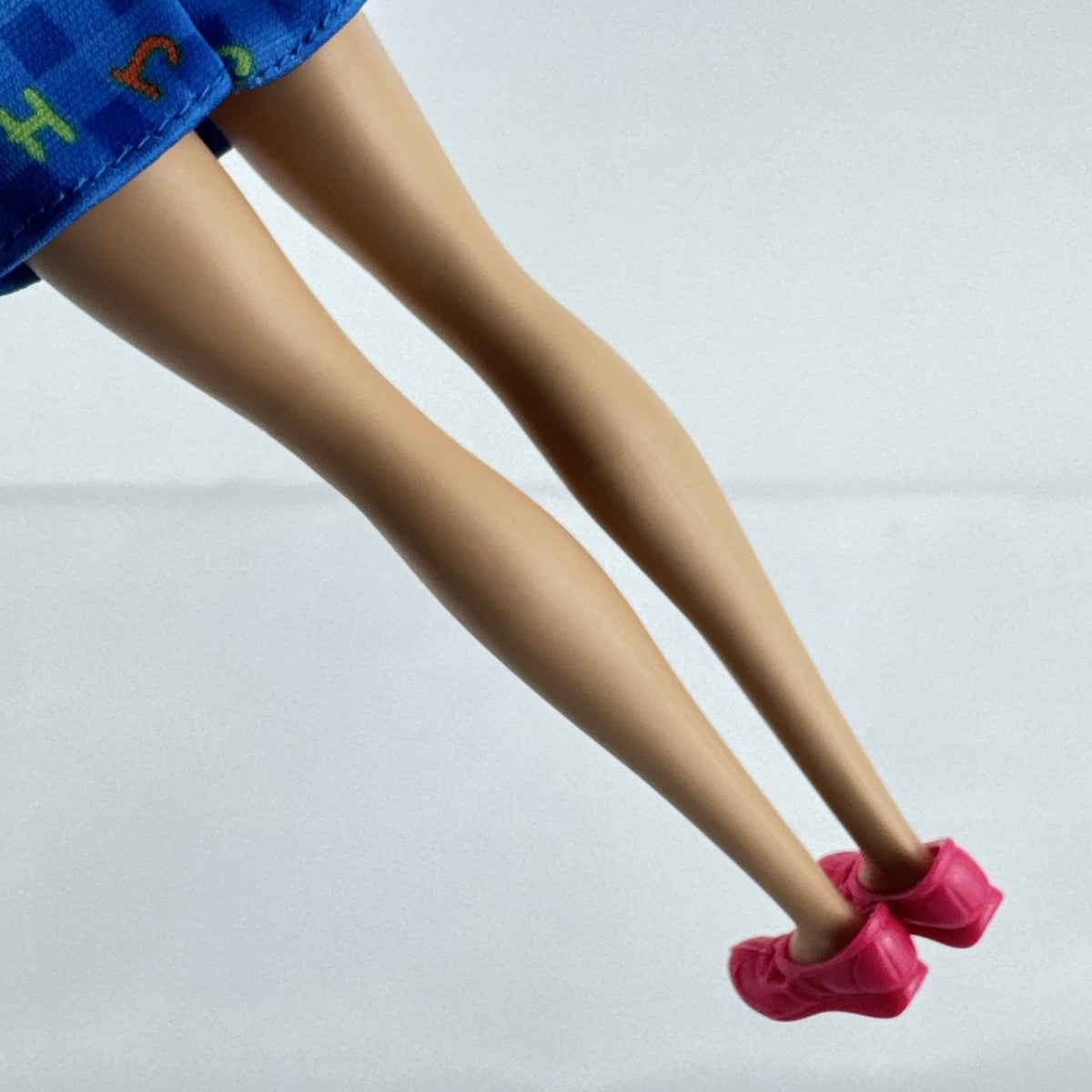 Mattel Barbie Careers teacher doll with blonde hair bun wearing a blue alphabet dress and pink shoes
