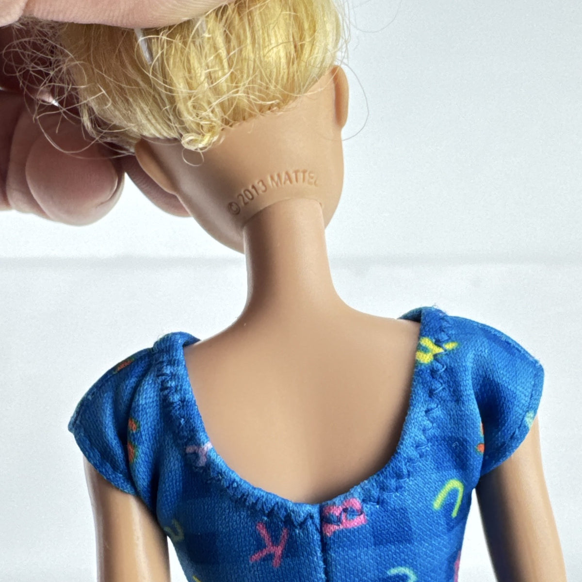 Mattel Barbie Careers teacher doll with blonde hair bun wearing a blue alphabet dress and pink shoes