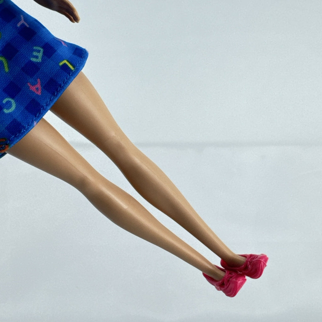 Mattel Barbie Careers teacher doll with blonde hair bun wearing a blue alphabet dress and pink shoes