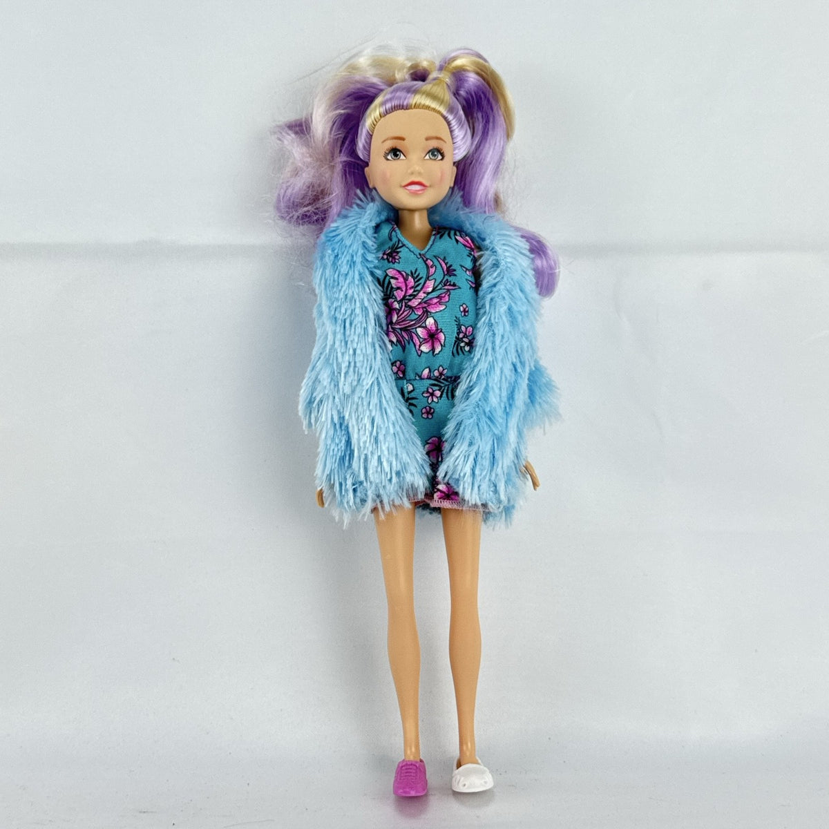 Just Play Hairdorables Hairmazing Harmony fashion doll with purple hair, floral romper, and light blue faux fur vest