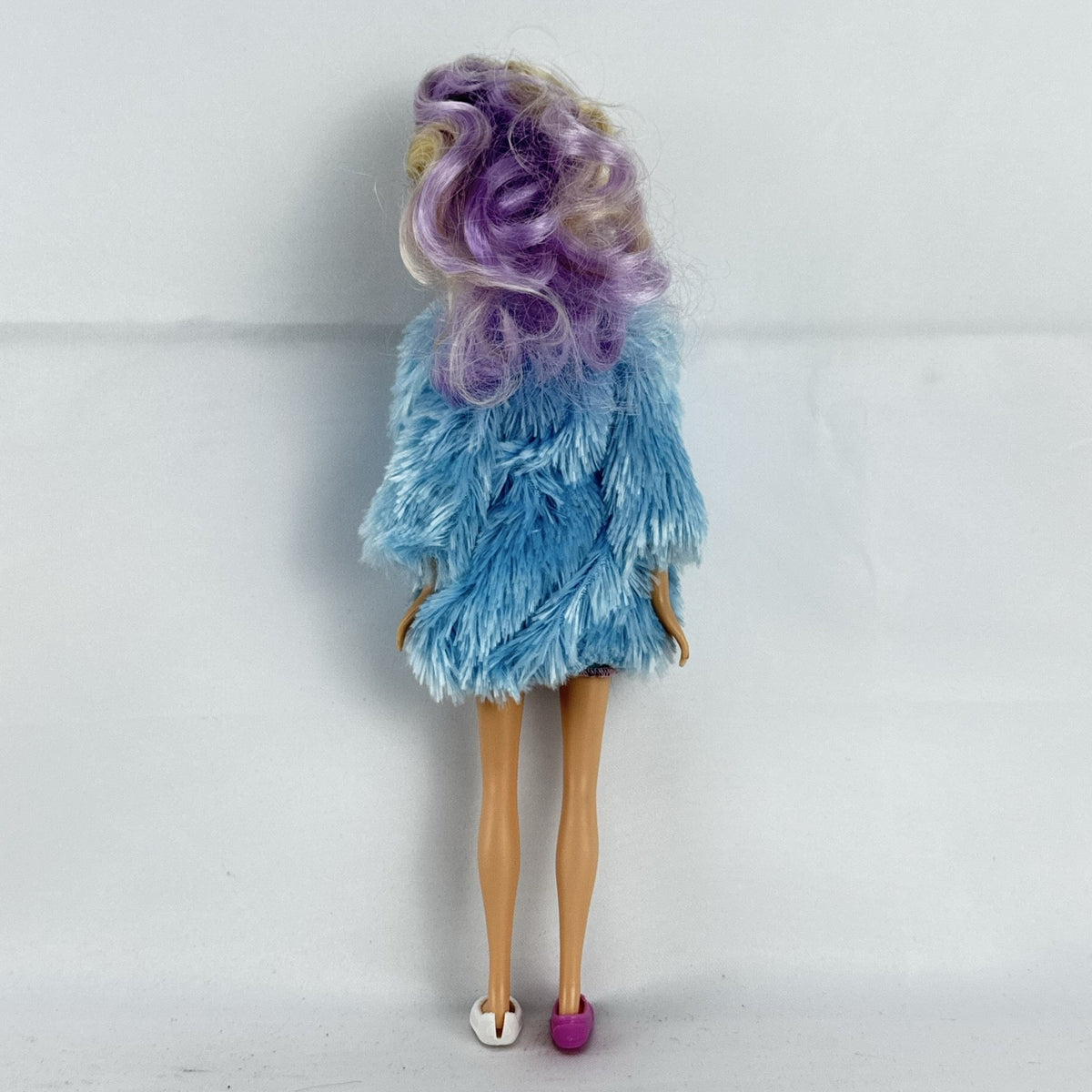 Just Play Hairdorables Hairmazing Harmony fashion doll with purple hair, floral romper, and light blue faux fur vest