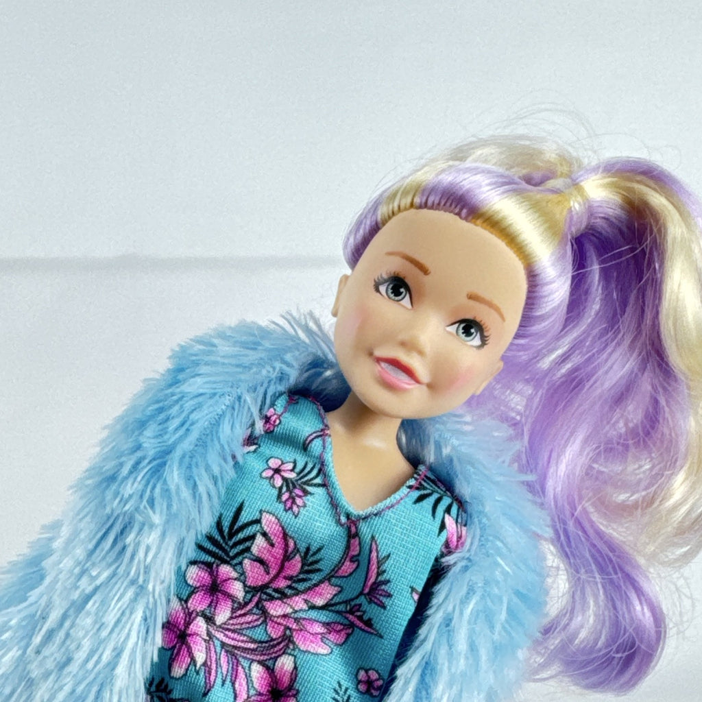 Just Play Hairdorables Hairmazing Harmony fashion doll with purple hair, floral romper, and light blue faux fur vest