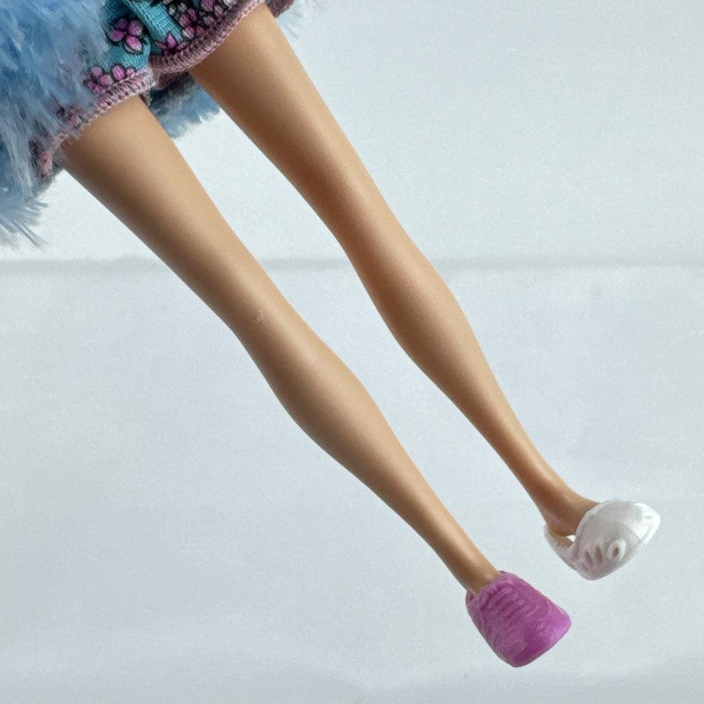 Just Play Hairdorables Hairmazing Harmony fashion doll with purple hair, floral romper, and light blue faux fur vest