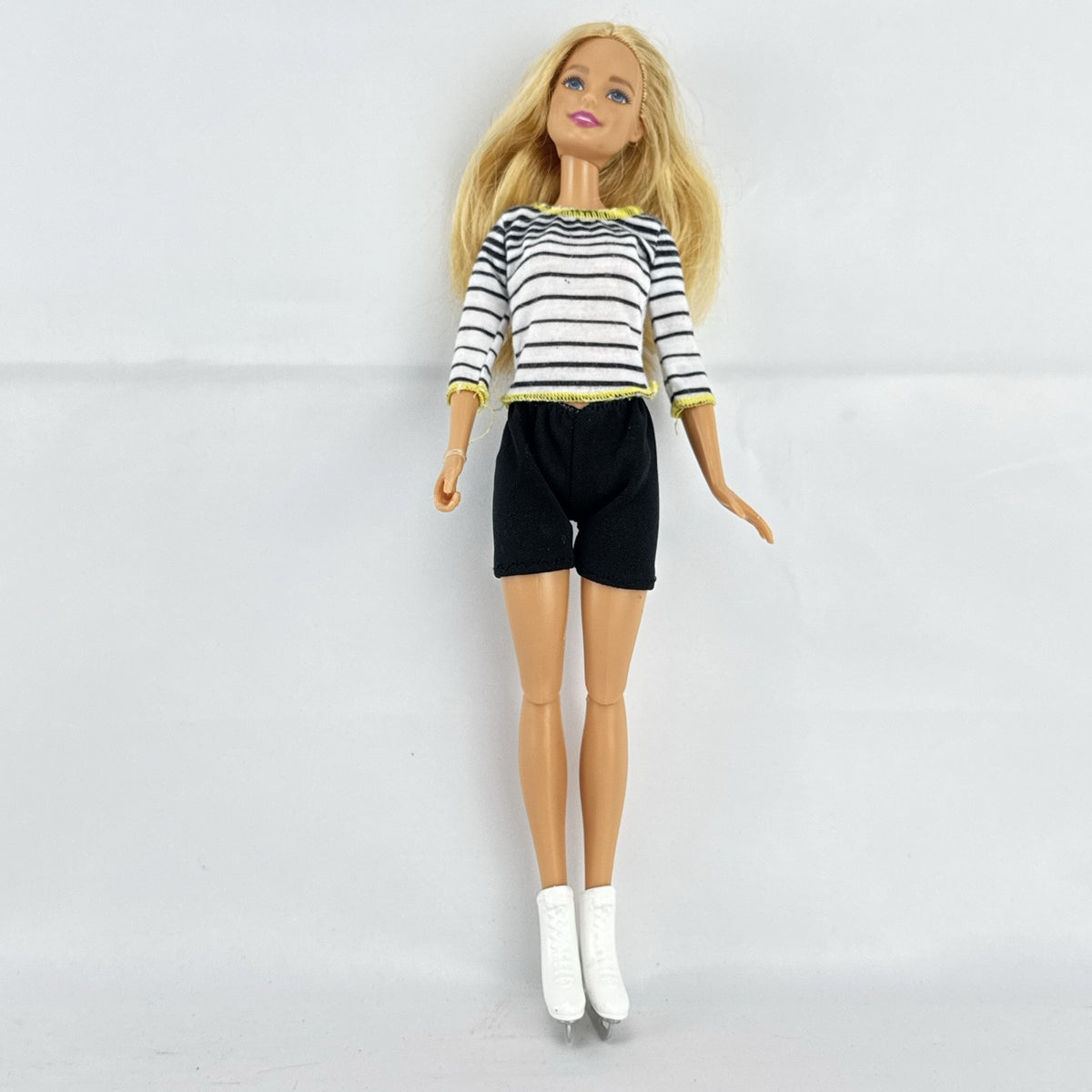 Mattel Barbie blonde ice skater doll with articulated knees wearing a striped athletic outfit and white skates