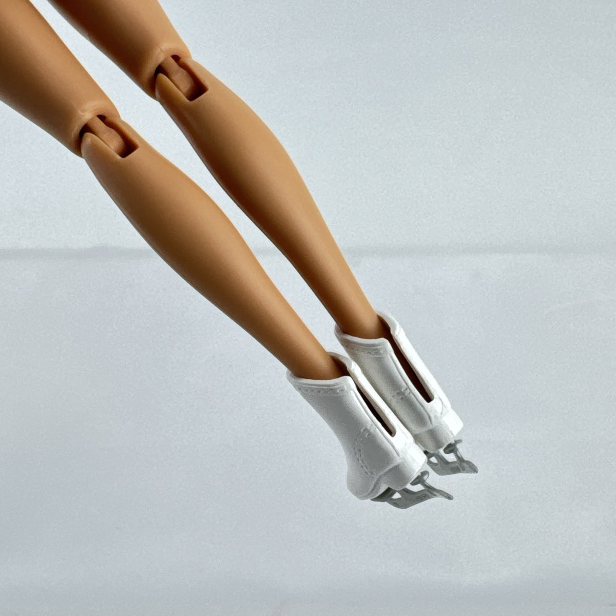 Mattel Barbie blonde ice skater doll with articulated knees wearing a striped athletic outfit and white skates