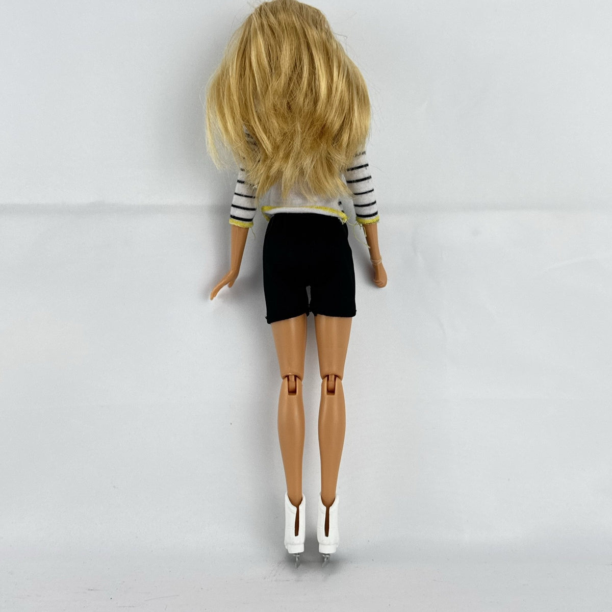 Mattel Barbie blonde ice skater doll with articulated knees wearing a striped athletic outfit and white skates