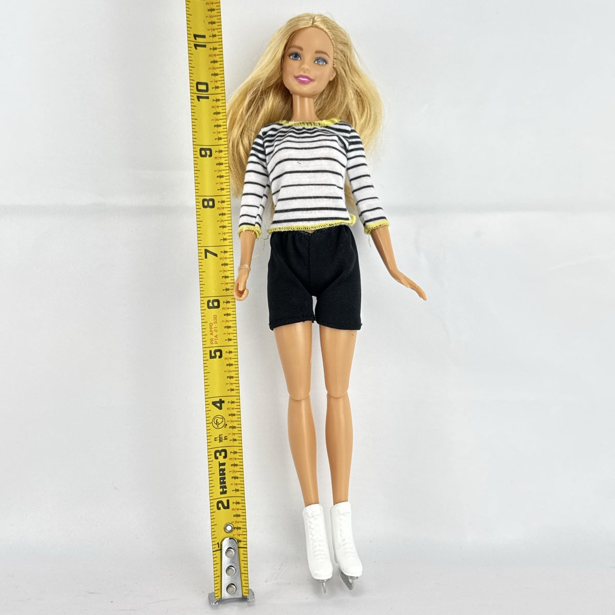Mattel Barbie blonde ice skater doll with articulated knees wearing a striped athletic outfit and white skates