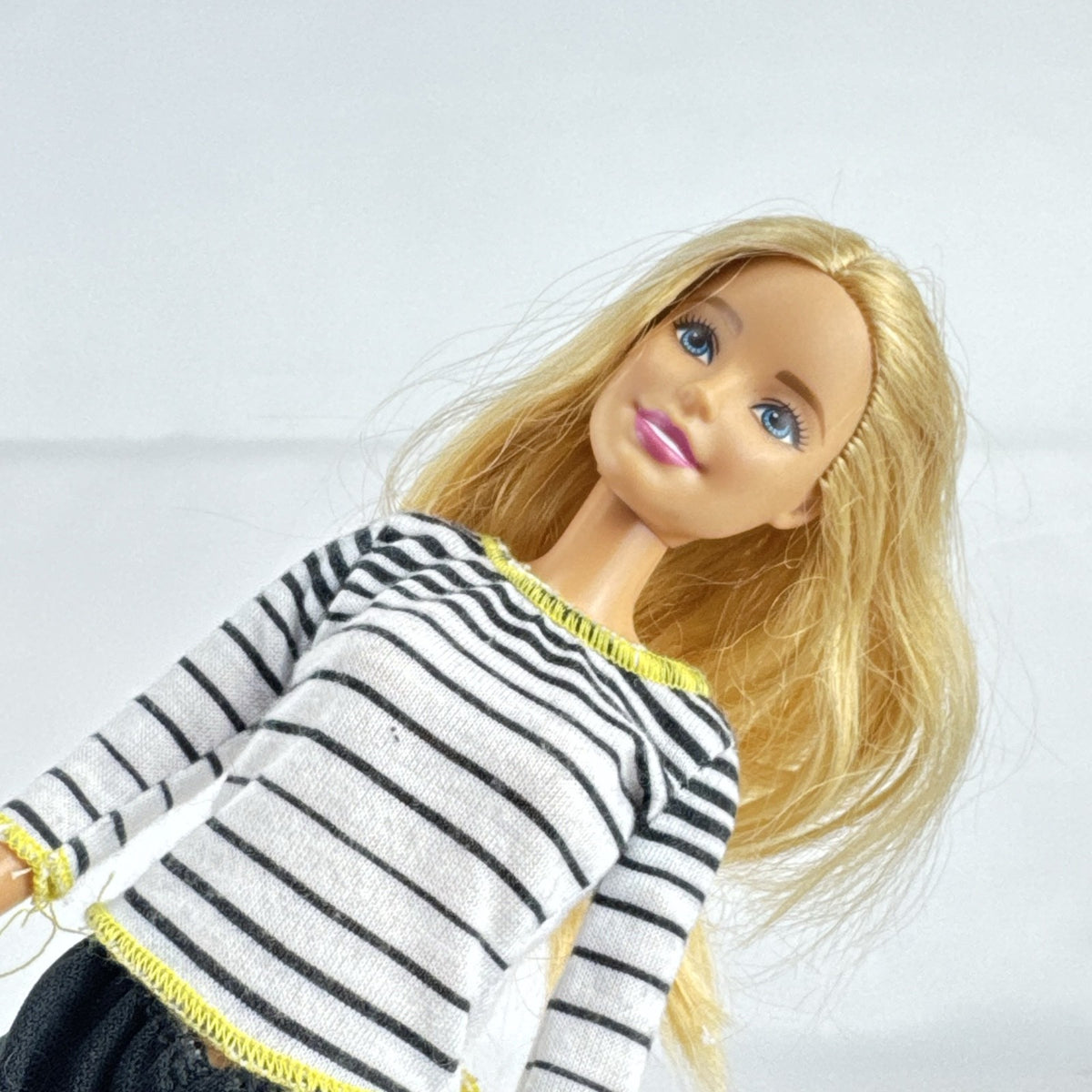 Mattel Barbie blonde ice skater doll with articulated knees wearing a striped athletic outfit and white skates