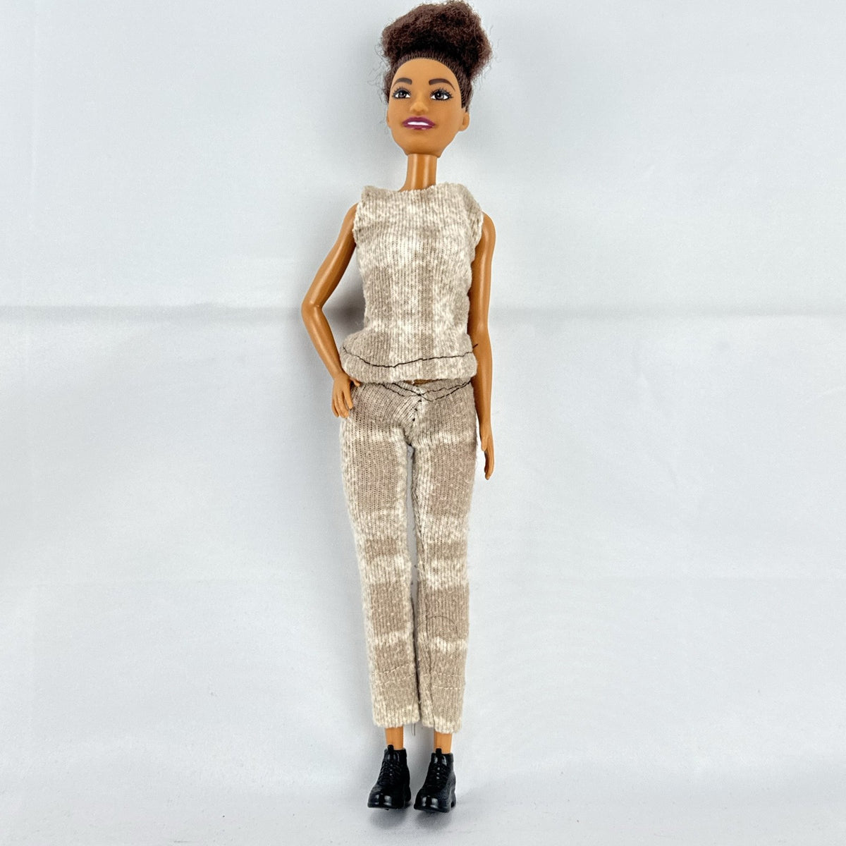 Mattel Barbie Fashionistas doll with topknot bun, wearing a heathered knit two-piece outfit and black ankle boots.