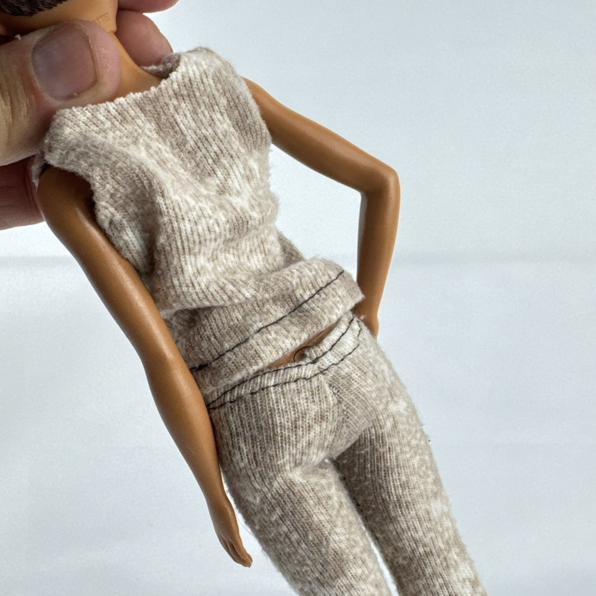 Mattel Barbie Fashionistas doll with topknot bun, wearing a heathered knit two-piece outfit and black ankle boots.